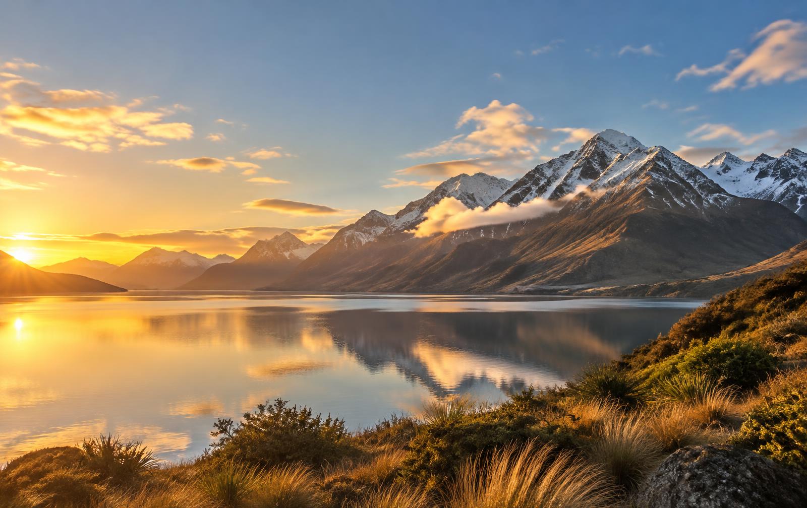 Lake and snow-capped mountains in New Zealand at golden hour